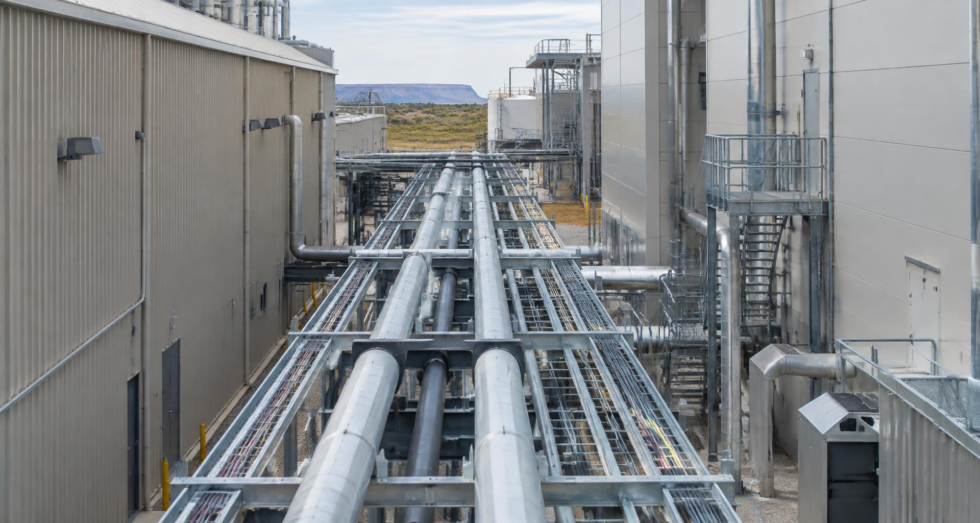 Parallel pipelines and cable trays connecting industrial buildings